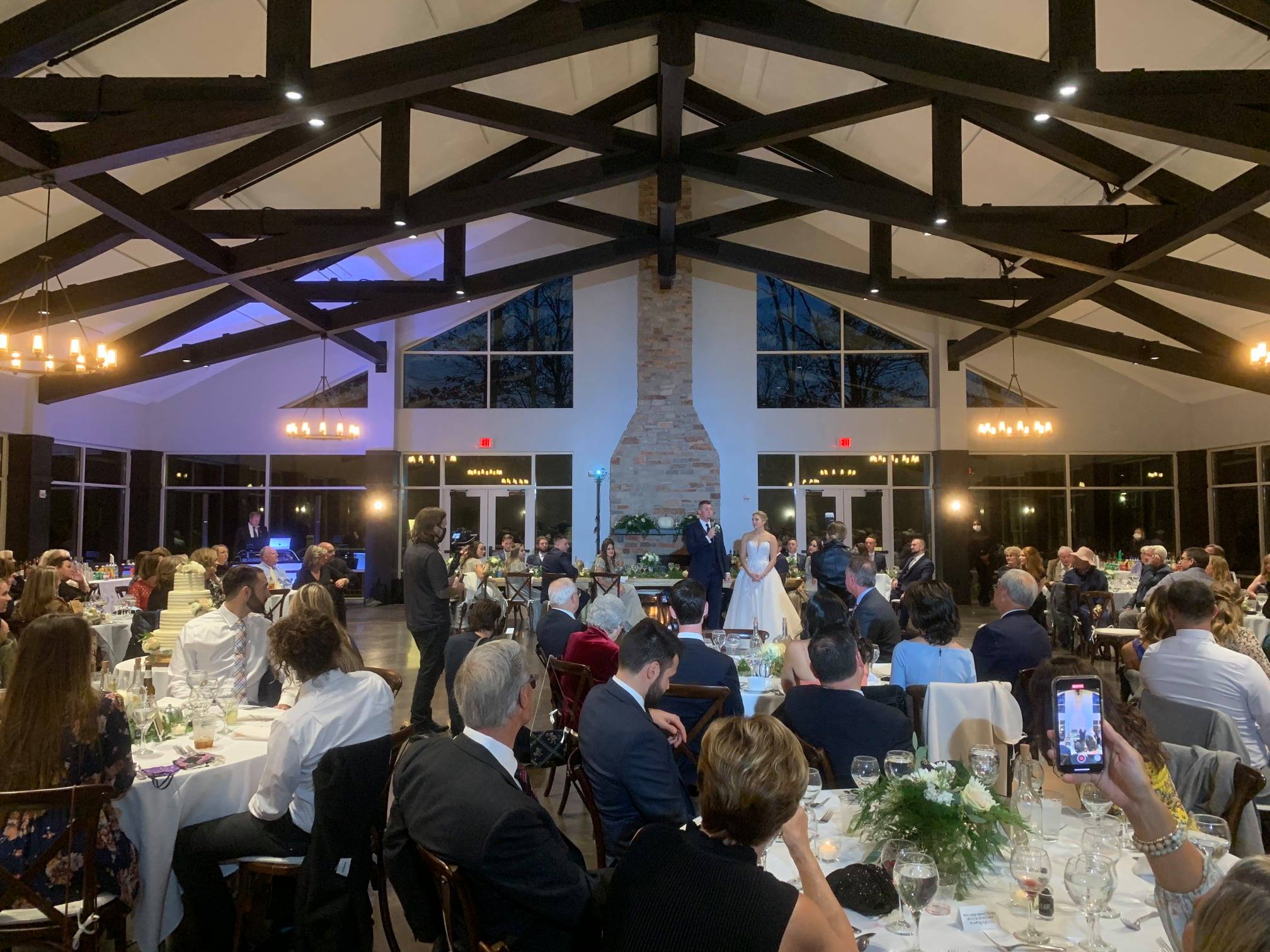 Couple speaking on microphone inside wedding venue